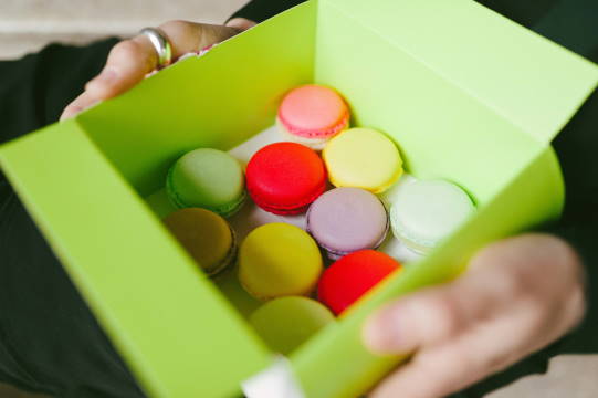 Eine grüne Schachtel voll mit bunten Macarons.